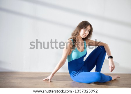 Young attractive woman practicing yoga. Girl is doing yoga. Stretching, working out, wearing sportswear. 