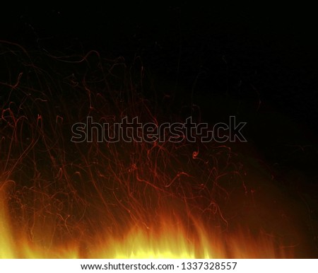 abstract bright fire sparkles lines on black night background. Dark picture of evening light bonfire. Orange yellow flashes of flame. Colorful designer postcard of burning energy.