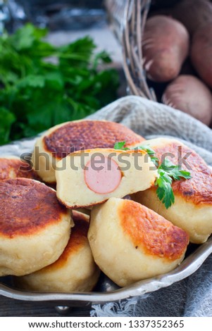 Sausage in potato dough on a metal dish, selective focus