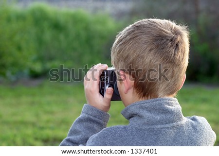 Back view of a young boy taking a picture.