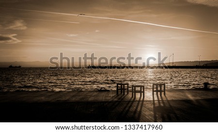 Chairs by the sea at sunset Royalty-Free Stock Photo #1337417960