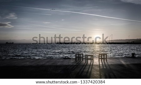 Chairs by the sea at sunset Royalty-Free Stock Photo #1337420384