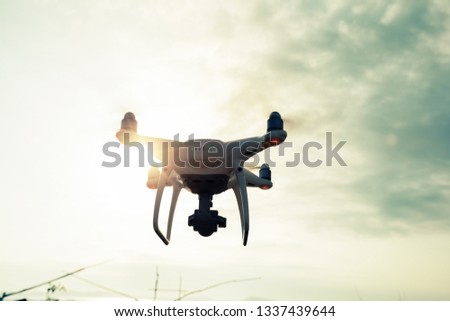 Drone flying in the air under cloudy sky