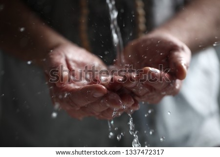 Muslim man washes his hands before prayer ritual cleansing. Royalty-Free Stock Photo #1337472317