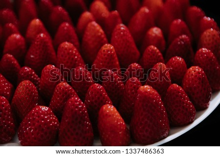 strawberry on white plate on black background