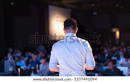 Presenter at Conference Meeting Event Photo. Speaker on Stage at Business Seminar. Audience Watching a Manager Presentation.
Blurred Image of Lecturer Presenting To Audience During Speech.  Royalty-Free Stock Photo #1337491094