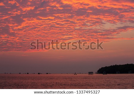 Fishing boat in tropical sea with beautiful morning sun color orange time