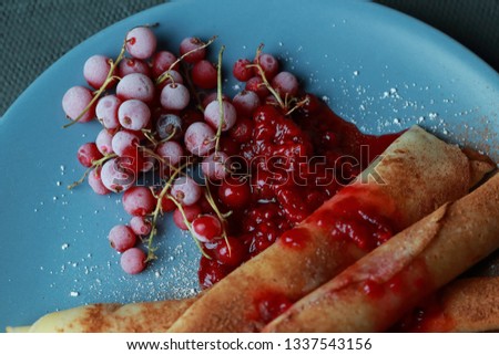 pancakes with berries, jam, honey and chocolate, sprinkled with powdered sugar and cinnamon