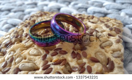 Two unusual multicolor wedding rings laying together