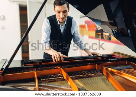 Pianist sets the grand piano before performance