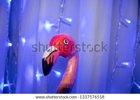 pink wooden flamingo statue on a blue background