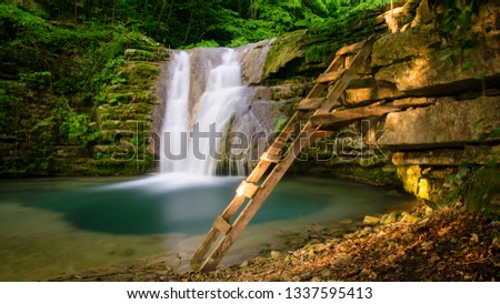 waterfall and stairs in green forest Royalty-Free Stock Photo #1337595413