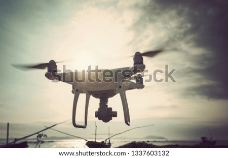Drone flying in the air under cloudy sky