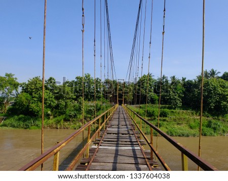 Broken old  wooden bridge above the river, near Yogyakarta province. Indonesia.