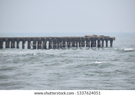 Broken bridge and broken pillars at seashore  Royalty-Free Stock Photo #1337624051