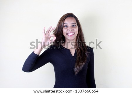 Happy woman gesturing ok smiling with white teeth looking at camera isolated on studio blank background, pretty girl hand showing okay sign satisfied with dental orthodontic service concept, portrait 