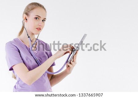Girl doctor blonde gray background one beautiful listen stethoscope look tablet smiling positive. Online patient consultation.Treatment distance. Communication hospital.