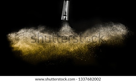 golden powder splash and brush for makeup artist or beauty blogger in black background