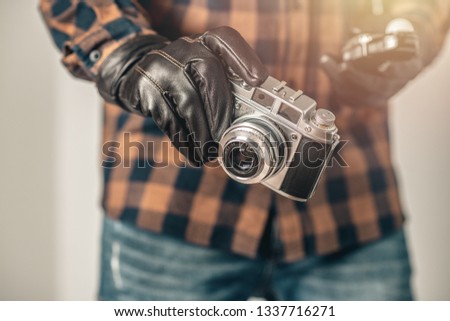 Old film camera in man's hand. Photography and hobby concept. 