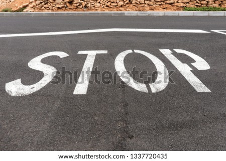 White Stop sign on black asphalt on floor