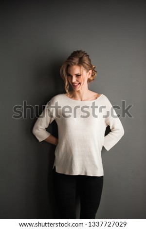 Beautiful woman wearing casual standing near grey wall