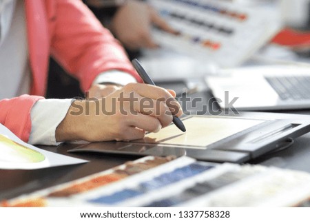 close up. a graphic designer uses a graphics tablet sitting at Desk in Studio