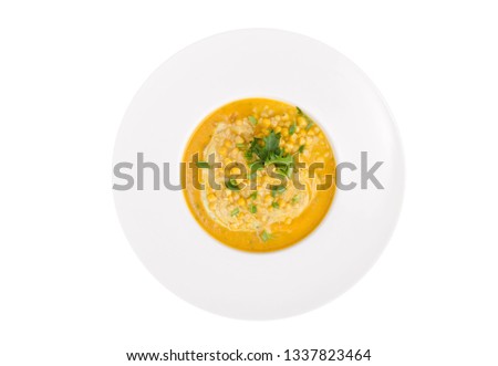 White plate with corn mash soup. Studio Photo