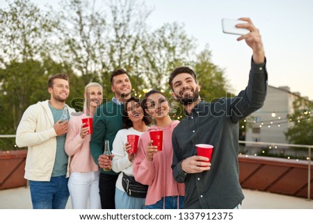 leisure and people concept - happy friends with non alcoholic drinks taking selfie by smartphone at rooftop party in summer