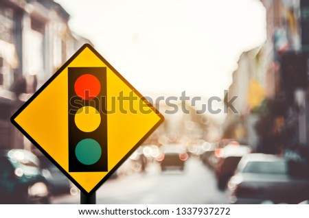 Traffic light warning sign on blur traffic road with colorful bokeh light abstract background. Copy space of transportation and travel concept. Retro tone filter color style.