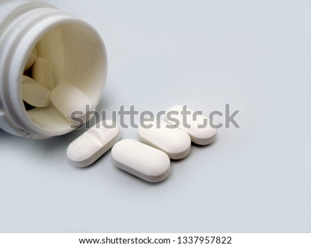 An opened tablet bottle with tablets of Paracetamol. Paracetamol (acetaminophen) is a pain reliever and a fever reducer. It is used to treat many conditions such as headache, muscle aches, arthritis,  Royalty-Free Stock Photo #1337957822