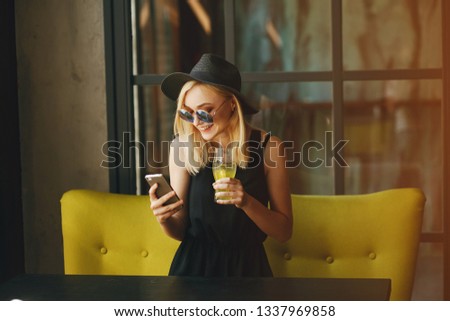 beautiful young gir sitting in the cafe and drink cocktail