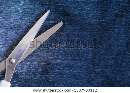 Dressmaker's shears laying on the blue jeans background. Jeans, tailoring, trends and fashion concepts Royalty-Free Stock Photo #1337983112
