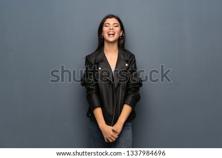 Teenager girl over grey wall shouting to the front with mouth wide open