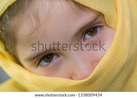 young girl with a veil covering her, close up, studio picture