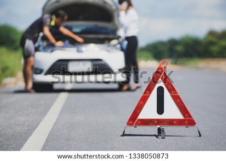 Red emergency stop sign and white car after accident on the road                 