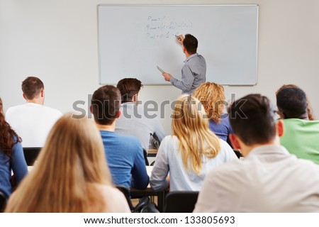 Teacher on whiteboard in class teaching business studies in university Royalty-Free Stock Photo #133805693
