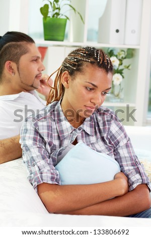 Image of young upset female feeling alone with her husband on background