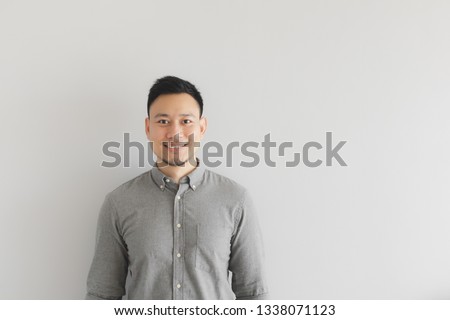 Smile happy face of ordinary Asian man in grey shirt. Concept of charming and positive thinking. Royalty-Free Stock Photo #1338071123