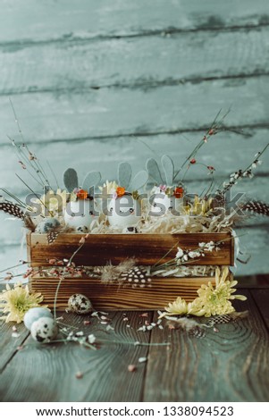 Easter background, homemade eggshell bunnies and yellow chrysanthemum in wooden box for beautiful holiday design of cards