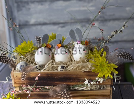 Easter background, homemade eggshell bunnies and yellow chrysanthemum in wooden box for beautiful holiday design of cards