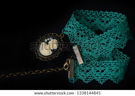 Green choker with girl cameo on a dark background close up