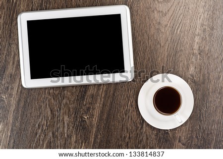 tablet and cup of coffee are on the table, still life