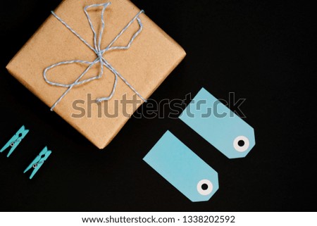 Handcrafted gift boxes wrapped in Craft paper  with blue paper card tag, rope and wooden  clothespins for decoration.