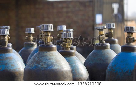 Row of liquefied oxygen industrial gas containers with valves. Close up of valves