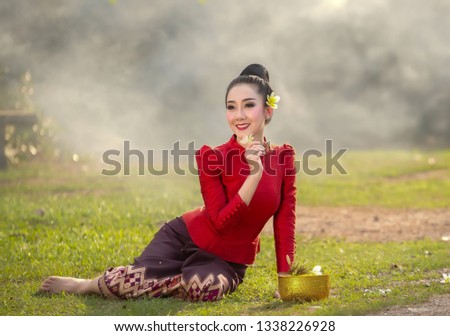 Asian Lifestyle and Vintage Lady With beautiful traditional dresses holding flowers in hand at Song-kran Cultural Festival,Thailand-Image.