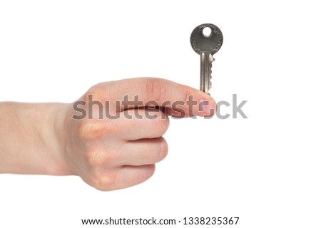 Human hand holding house key isolated on white background. Concept of new life and new home