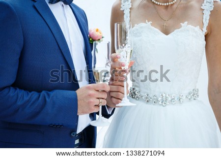 Glasses with sparkling champagne in the hands of the newlyweds