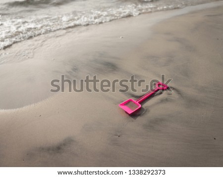 Pink beach shovel toy on the sand. 