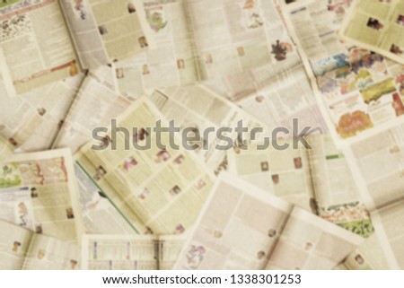 Lots of old newspapers on horizontal surface. Background texture, top view, blurred                         