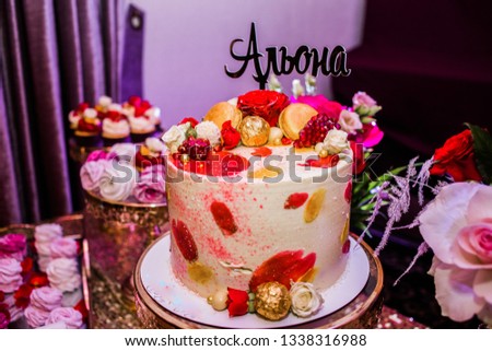 Fine cake decorated of candies and roses with the inscription "Alena". Candy Bar